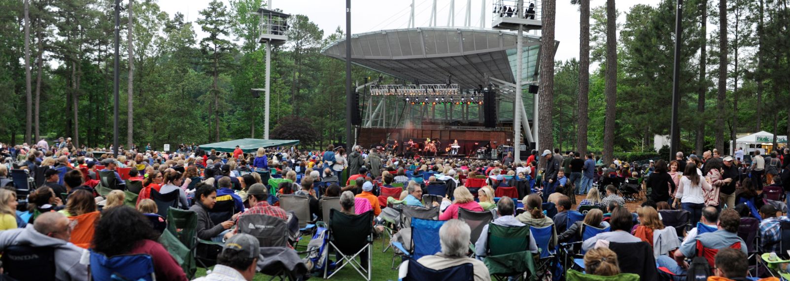 Crowd at the Koka Booth Amphitheatre surrounded by beautiful pine trees